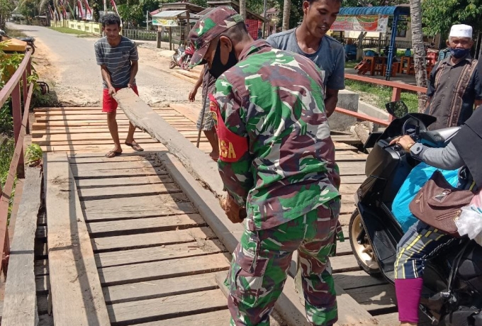 Babinsa Gotong Royong Bersama Warga Perbaiki Jembatan Yang Rusak