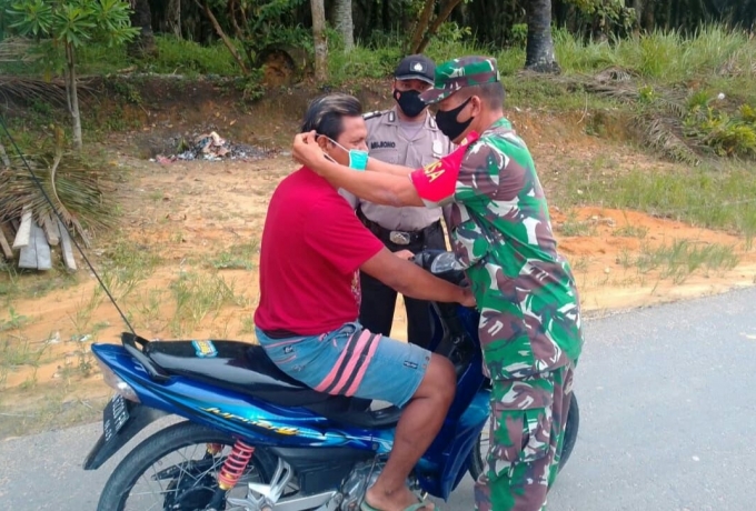 Babinsa Koramil 15/Kuala Kampar dan polsek Kerumutan bersinergi Tegur Warga yang Tidak Pakai Masker