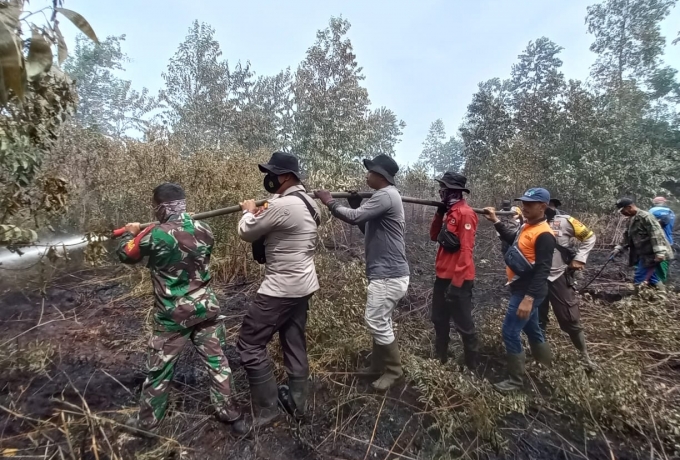 Sinergitas TNI dan Tim Gabungan Lakukan Pendinginan Karhutla Kondisi Panas Terik Di Desa Pulau Muda