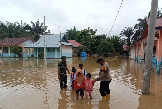 Banjir di Kabupaten Rokan Hulu, Babinsa bersama Bhabinkamtibmas Antar Jemput Anak Sekolah 