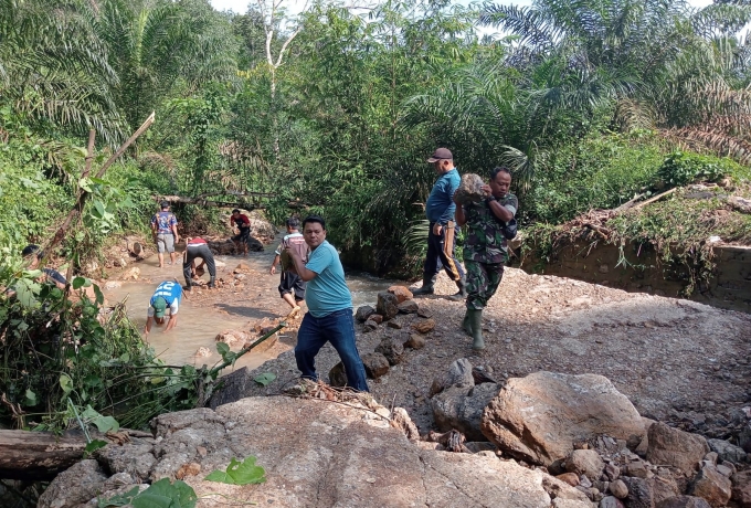 Serda Febrianto Bahu Membahu Bersama Warga Perbaiki Jembatan Yang Rusak Terseret Air Sungai