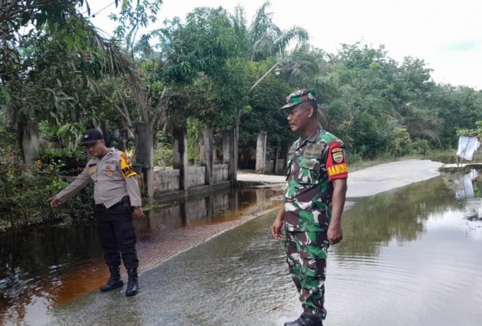 Wujud Perhatian, Babinsa Bersama Bhabinkamtibmas Pantau Lokasi Banjir di Wilayah Binaannya