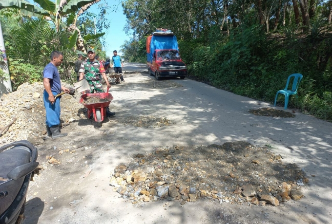 Babinsa Serka Ismansyah Laksanakan Goro Menimbun Jalan Berlubang Dengan Warga