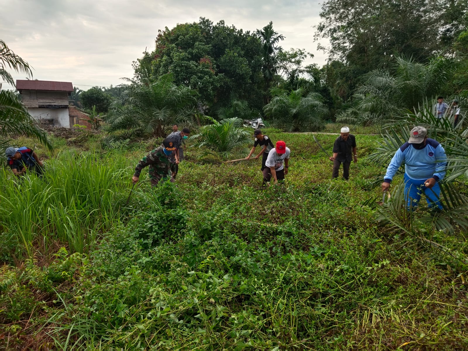 Babinsa Koramil 14/Kepenuhan Ajak Warga Bersihkan TPU