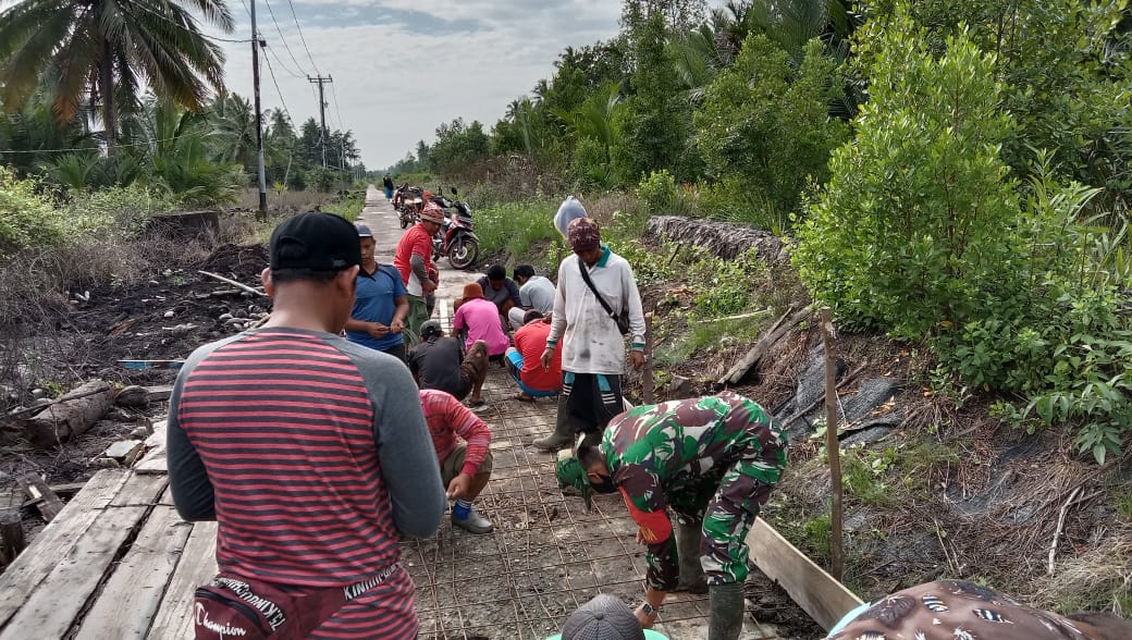 Babinsa Koramil 15/ Kuala Kampar Karya Bakti Gotong Royong Semenisasi Jalan Desa