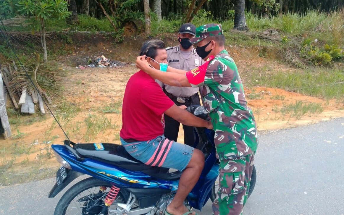 Babinsa Koramil 15/Kuala Kampar dan polsek Kerumutan bersinergi Tegur Warga yang Tidak Pakai Masker