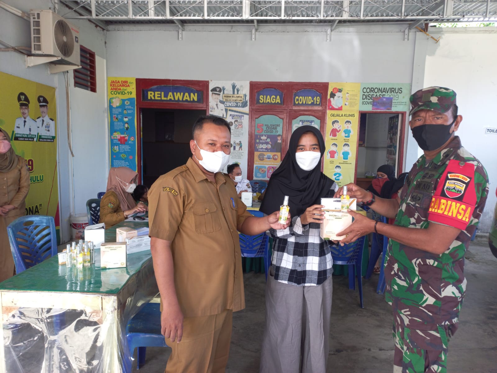 Pelda Budiman Babinsa Desa Pandau Jaya Mengawasi Pelaksanaan Vaksinasi dan Bagikan Masker