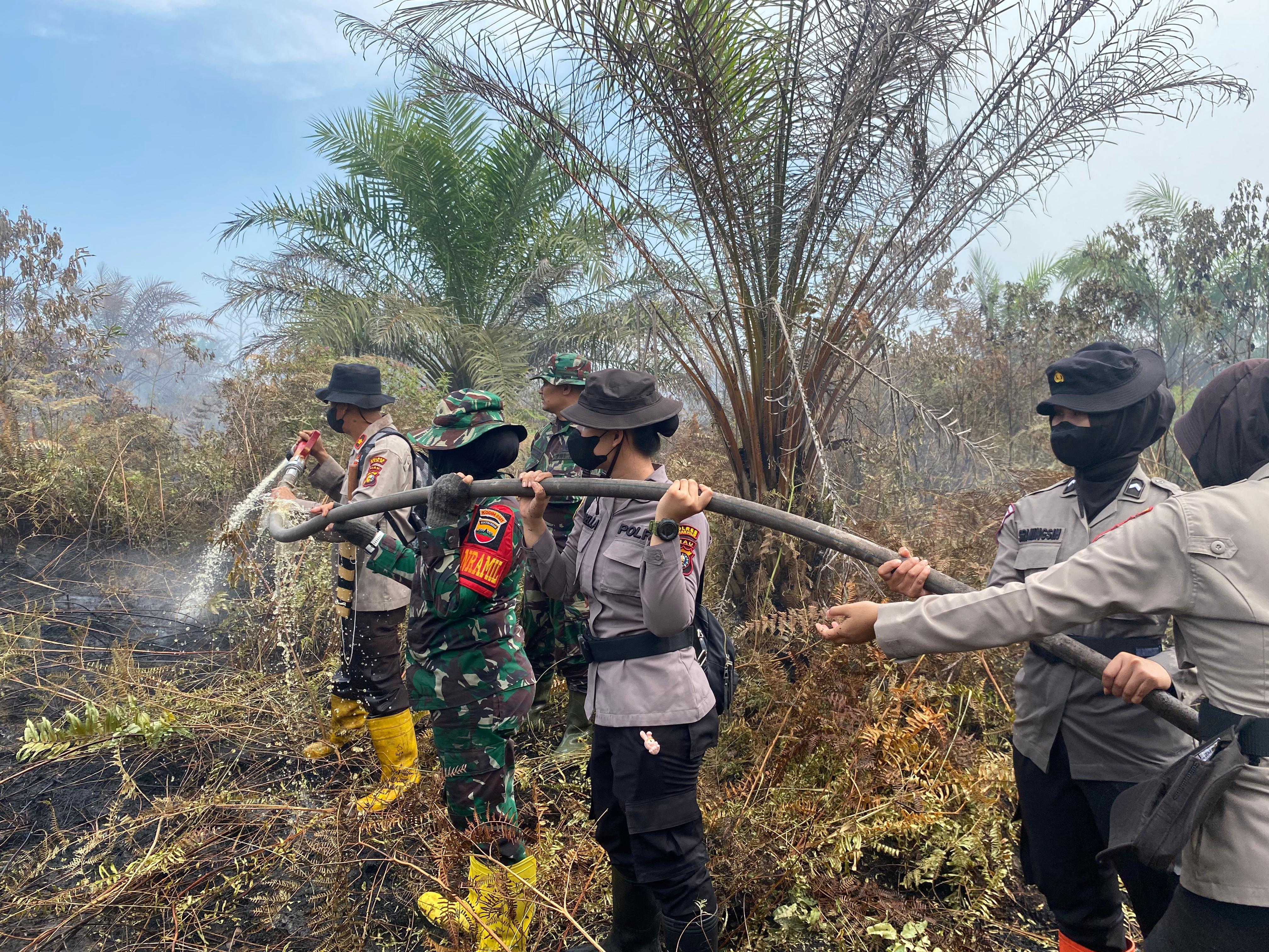 Srikandi Danramil dan Polwan Polres Rohil ikut Memadamkan Api di Rohil