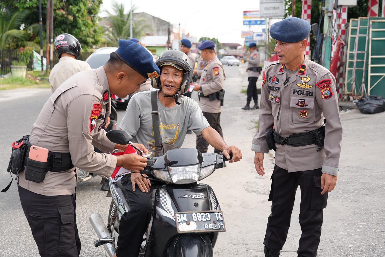 Tingkatkan rasa Nasionalisme, Brimob Polda Riau Bagikan Bendera Merah Putih Ke Masyarakat