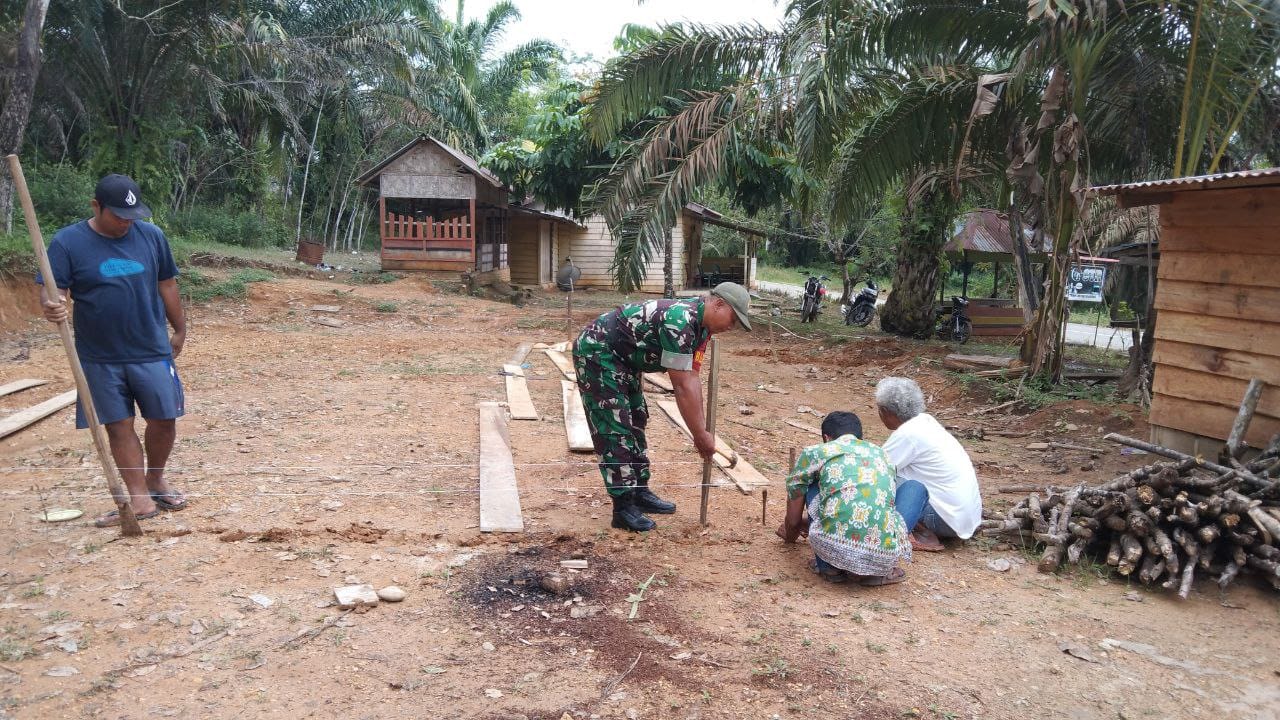 Babinsa Koramil 13/Rokan IV Koto Bantu Warga Bangun Pondasi Rumah di Desa Sei Kandis