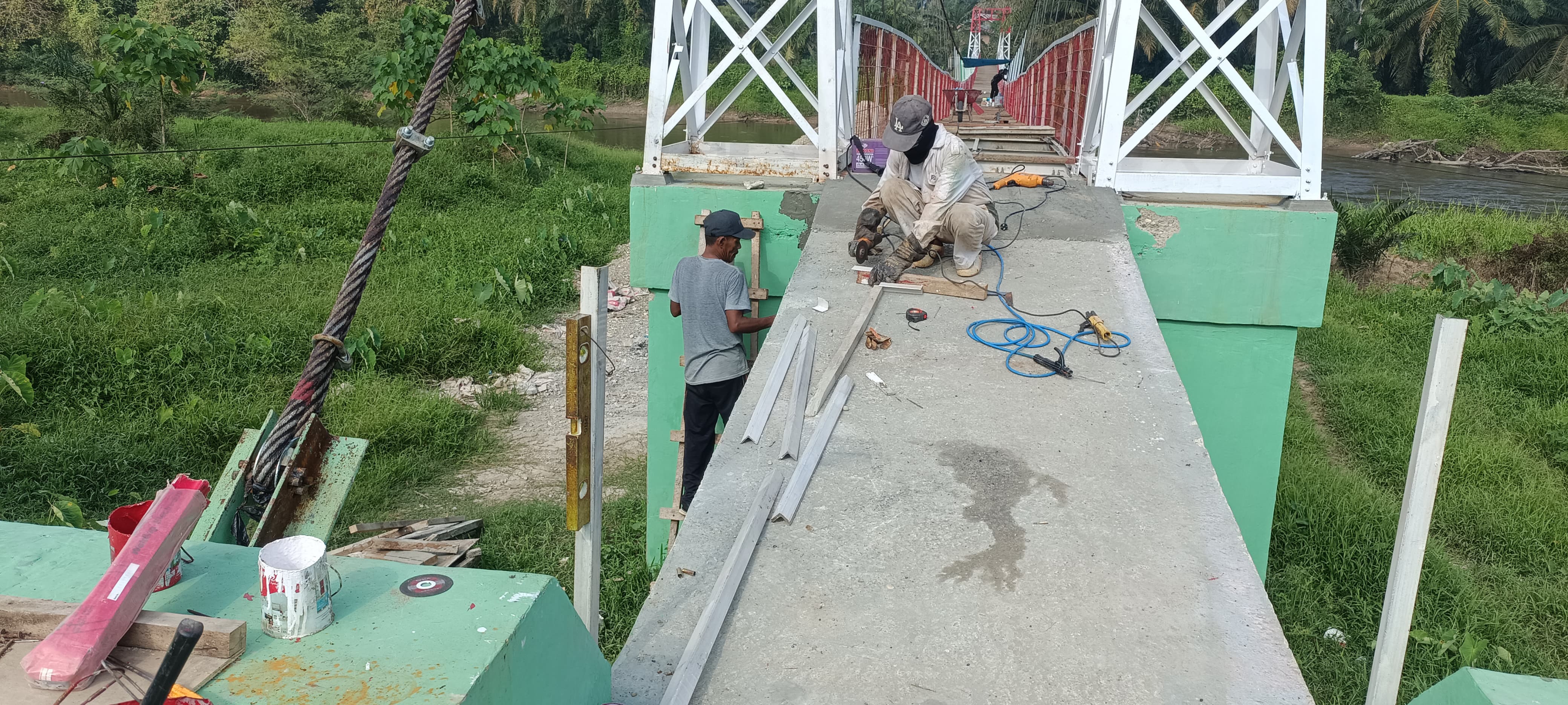 Mengejar Target Peresmian, Tim Lapangan Percantik Jembatan Desa Muara Musu 