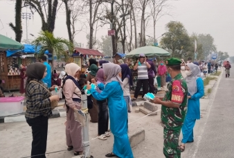 Babinsa Bersama Petugas Kesehatan Bagikan Masker kepada Masyarakat